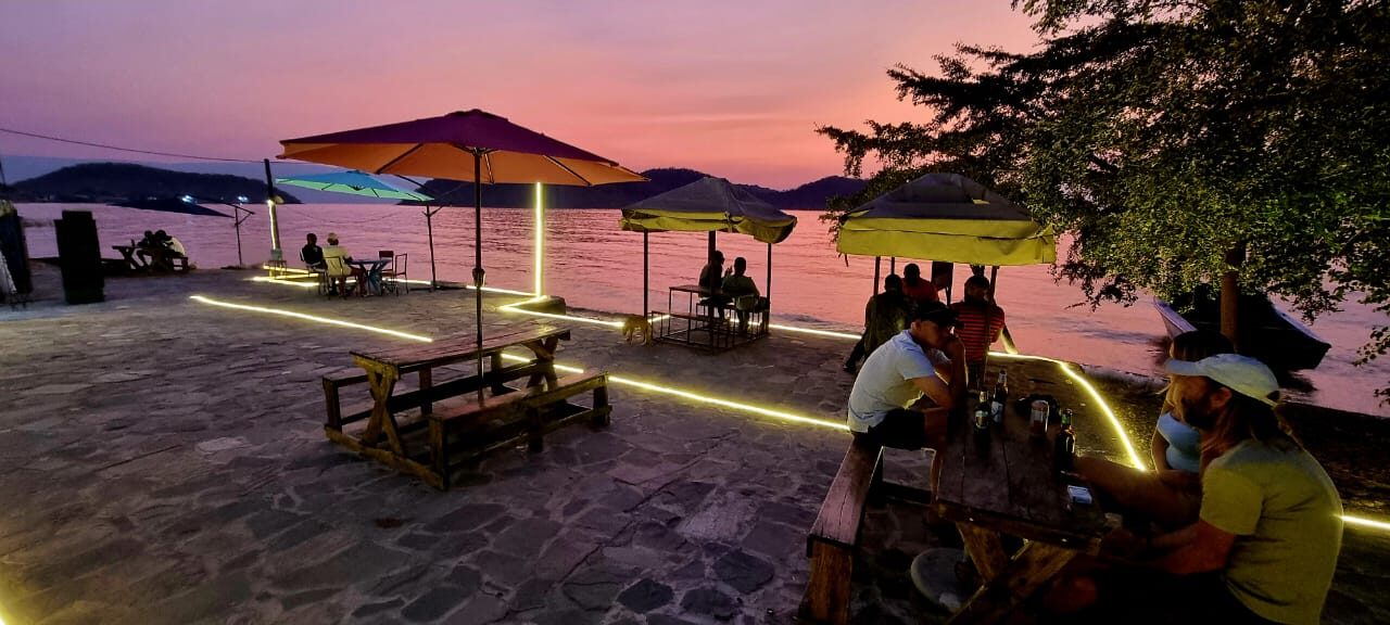 Guests relaxing on the shore of Lake Tanganyika at dusk
